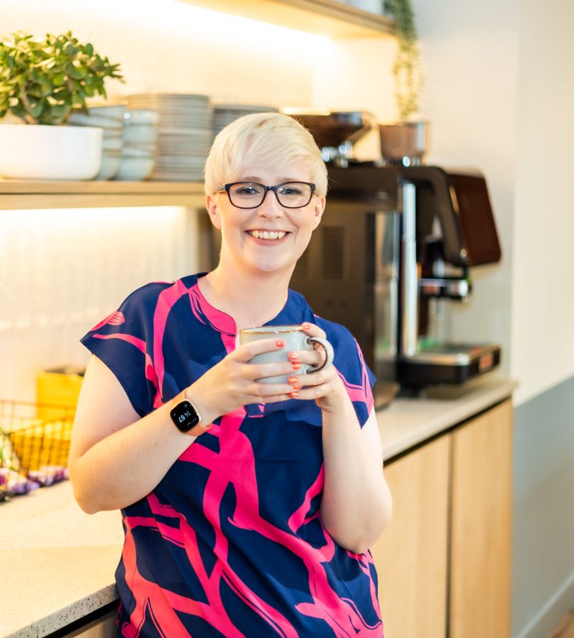 Jenny Lucas in a kitchen, holding a mug